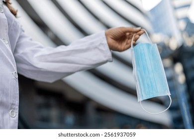 Hand holding mask, outdoor and closeup on road for health, wellness and safety from virus. Person, medical ppe and cloth for virus, bacteria and freedom on city street.