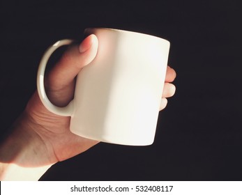 Hand Holding A Matte White Mug