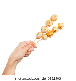 Hand holding meatball stick with spicy sauce isolated on white background, clipping path