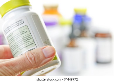 Hand Holding Medicine Bottle To Read Label
