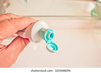 Hand Holding A Messy Toothpaste Tube