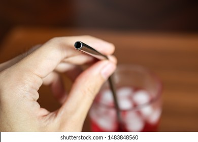 Hand Holding Metal Straw In A Glass Of Red Sweet Drink