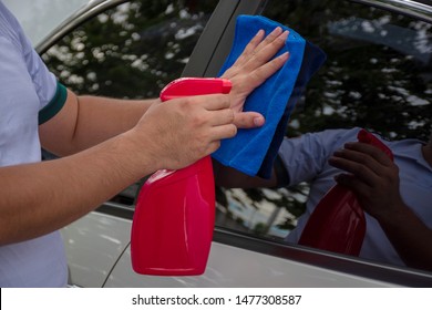 Hand Holding A Microfiber Cloth Wiping The Car And Spray The Glass Cleaner