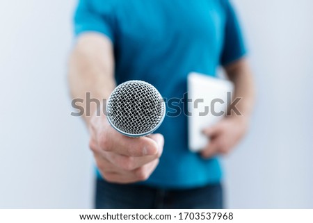 Hand holding a microphone conducting a business interview or press conference