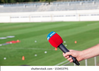 Hand Holding Microphone For Interview During A Football Mach