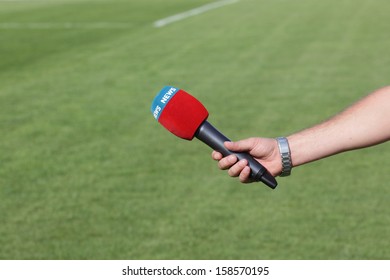 Hand Holding Microphone For Interview During A Football Mach