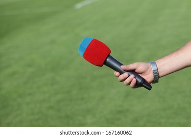 Hand Holding Microphone For Interview During A Football Mach