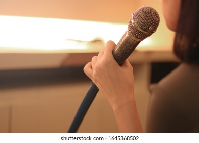 Hand Holding Microphone To Sing A Song, Karaoke Or Vocal Training Concept. 