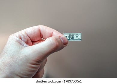 Hand holding miniature dollar note. the concept of dollar inflation. cash on hand.