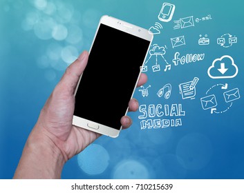 hand holding mobile phone with cloud computing with blue background .Hand holding smartphone with hand drawn media icons and symbols concept style. - Powered by Shutterstock