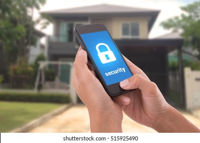 Hand Holding Mobile Phone With Concept Technology Home Security System.