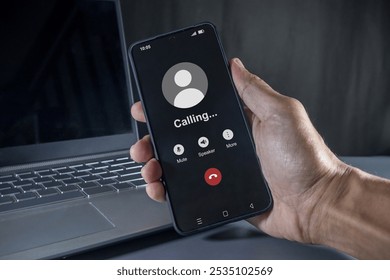 Hand holding a mobile phone with outgoing call screen. Call someone with a voice call. - Powered by Shutterstock