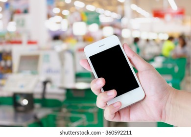 Hand Holding Mobile Phone At Supermarket Checkout Background, Digital Wallet Concept