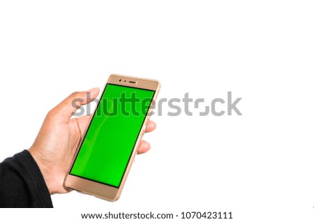 A hand holding mobile smart phone with green screen against white background
