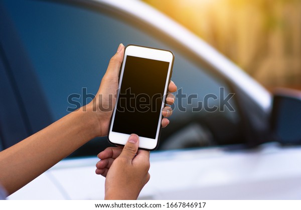 Hand holding mobile smart phone application\
to start car technology smart life\
5G