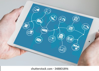 Hand Holding Modern Tablet. Internet Of Things (IOT) Business Model With World Map On Blue Background. 