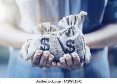 Hand Holding Money Bag. Concept Saving Finance And Accounting