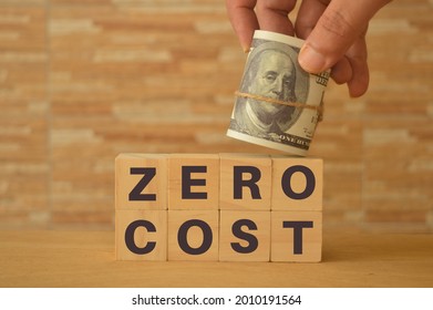 hand holding money banknote on wooden blocks with text ZERO COST. - Shutterstock ID 2010191564