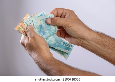 Hand holding money, six hundred reais, Brazilian currency, on white background. - Shutterstock ID 2190718365