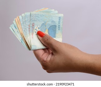 Hand holding money, six hundred reais, Brazilian currency, on white background. - Shutterstock ID 2190923471