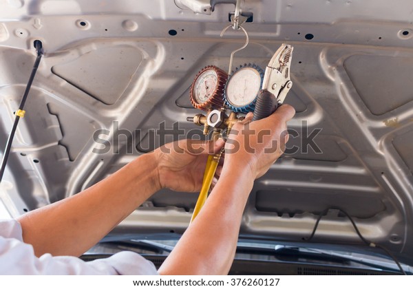 hand holding\
monitor tools car air of car\
garage