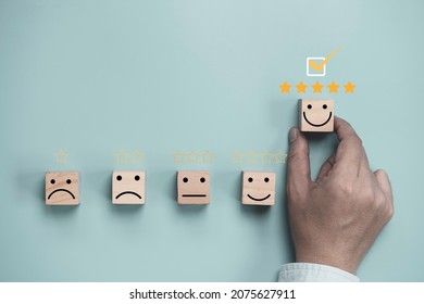 Hand Holding And Move Up Wooden Cube Block Which Print Screen Smiley Face With Five Stars For Client Customer Satisfaction After Use Product And Service Concept.