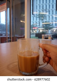 Hand holding a mug at cafe