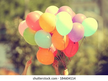 Hand Holding Multicolored Balloons