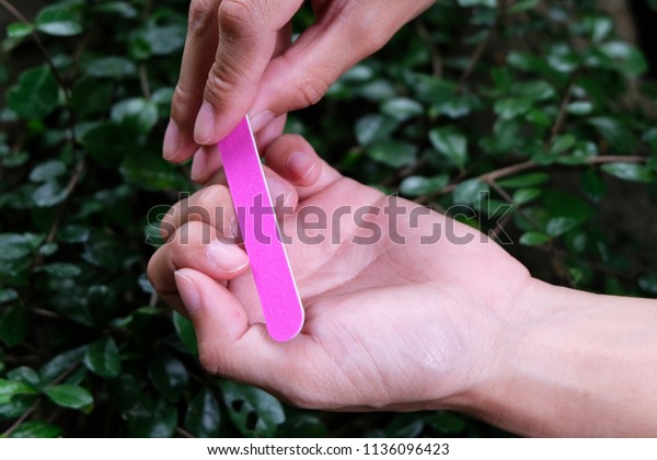 Hand holding nail files.,\
Nail Emery Board., Emery boards are generally less abrasive than\
the metal nail files and hence, emery boards may take longer to\
file down nails.