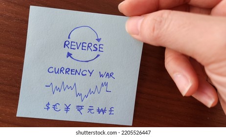 Hand Holding A Note Showing Reverse Currency War Concept