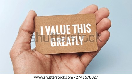 Hand holding note with I VALUE THIS GREATLY text, appreciation message concept expressing sincere gratitude, respect, recognition, and meaningful support. 