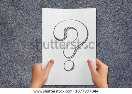 Hand holding a note written a question