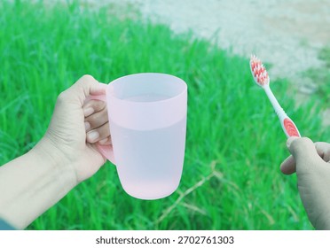 Hand holding an object for brushing teeth.