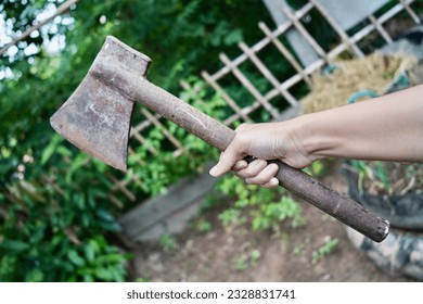 Hand holding the old axe for work.