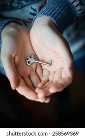 hand holding an old metal key  - Shutterstock ID 258569369