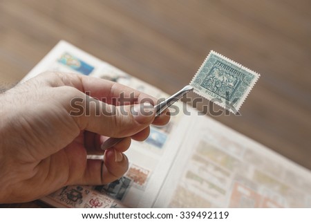 Hand holding an old Polish post stamp