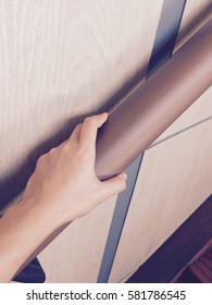 The Hand Holding On To A Wooden Banister. Closeup Of Senior Using The Wooden Railing Of Stairs To Go Upstairs At Home.