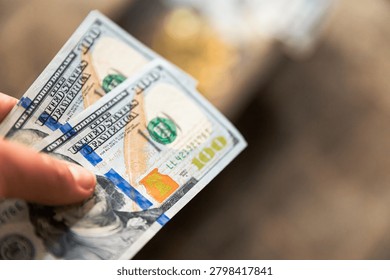 Hand holding one hundred dollar banknotes with large copy space for financial concepts