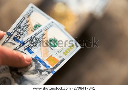 Hand holding one hundred dollar banknotes with large copy space for financial concepts