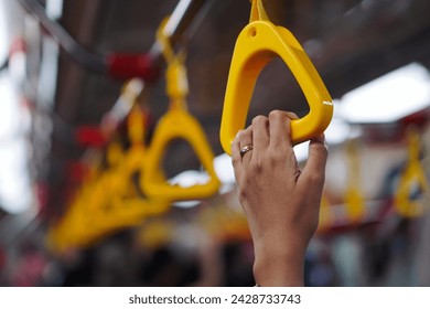 Hand holding onto grab handle - Powered by Shutterstock