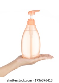 Hand Holding Orange Liquid Soap Bottle Isolated On White Background