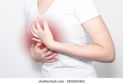 Hand holding pain point, suffering from heart or solar plexus ache. - Shutterstock ID 1856035462