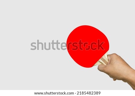 Hand holding Pair of red ping-pong rackets , isolated on white background