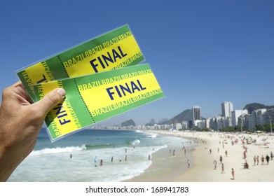 Hand Holding Pair Of Tickets To Final Football Soccer Sporting Event At Copacabana Beach Rio De Janeiro Brazil