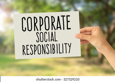 Hand Holding A Paper Card With Corporate Social Responsibility (CSR) Concept On Abstract Nature Background