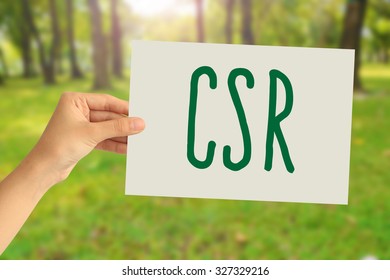 Hand Holding A Paper Card With Corporate Social Responsibility (CSR) Concept On Abstract Nature Background