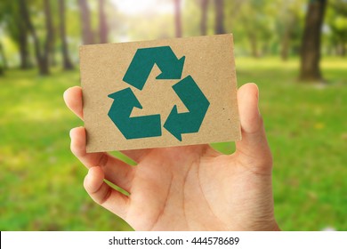 Hand Holding A Paper Card With The Recycling Sign