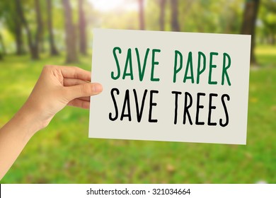 Hand Holding A Paper Card With Save Paper, Save Trees Word On Abstract Nature Background