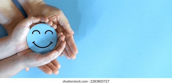 Hand holding paper cut circle symbol face smile, happy, relax,  satisfaction survey, customer services, positive, good, wellness, health child, hospital, world mental health day concept - Shutterstock ID 2283803727