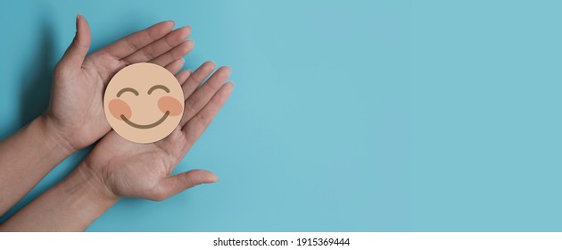 Hand Holding Paper Cut Smile Face, Positive Thinking, Mental Health Assessment , World Mental Health Day Concept